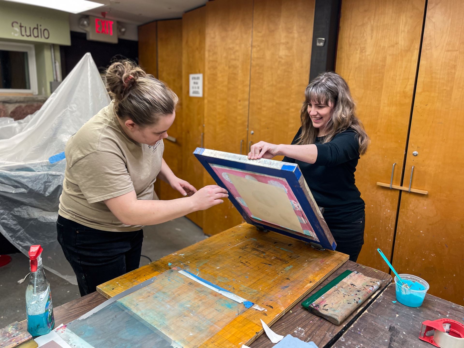Kath instructing an artist on how to screen print.